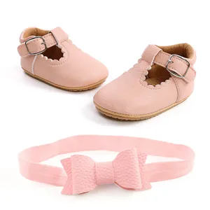 Vista dettagliata di scarpe da neonato in ecopelle rosa con fascia per capelli a fiocco