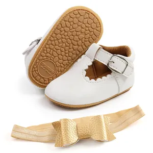Dettaglio delle scarpe da principessa per neonati bianche con bordi smerlati e suola antiscivolo.