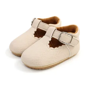 Close-up of beige baby princess shoes featuring scalloped edges and silver buckle detail.