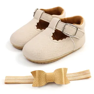 Dettaglio scarpe Mary Jane beige neonata e fascia per capelli con fiocco dorato