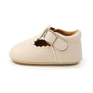 Detailed side view of beige baby princess shoes with scalloped edges and rubber soles.