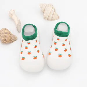 Close-up of baby walker sock shoes with cute orange cactus pattern and green cuff