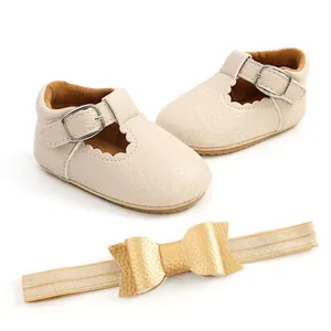 Vista dettagliata delle scarpine beige da principessa per neonata e fascia con fiocco oro