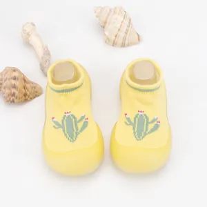 Close-up of yellow baby sock shoes with cute cactus embroidery and breathable knit