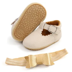 Dettaglio delle scarpe da principessa per neonati beige e fascia con fiocco oro