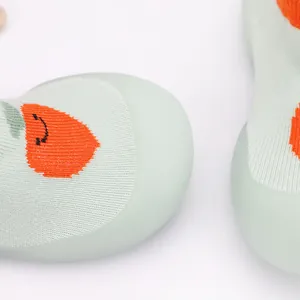 Macro detail view of breathable knit baby sock shoes with cute orange cactus pattern