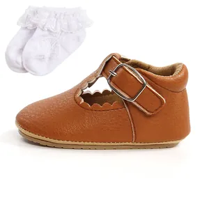 Dettaglio di scarpine in pelle marrone per neonati con calzini bianchi con volant