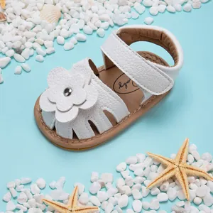 Vue détaillée d'une sandale d'été blanche pour bébé avec fleur et une semelle souple
