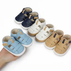 Close-up of light blue baby sandal held in hand showcasing color variety and soft material