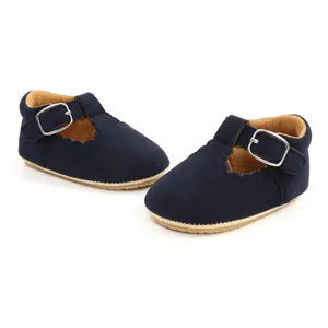 Macro view of navy blue suede baby girl walking shoes featuring elegant scalloped edges.