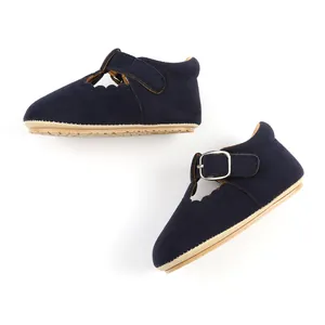 Close-up of navy blue suede baby girl Mary Jane shoes with scalloped edges and buckle.