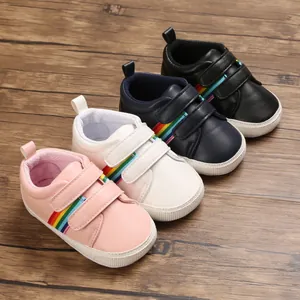 Vue rapprochée de chaussures bébé multicolores avec bandes arc-en-ciel et semelles souples