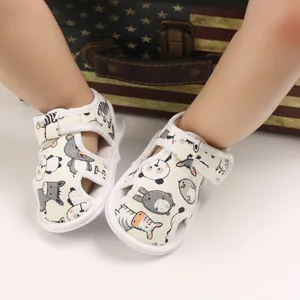 Primer plano de sandalias para bebé con suela blanda, estampados de animales y tiras de velcro.