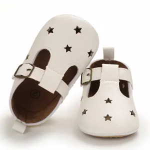 Detail view of white baby summer shoes featuring star cutouts and adjustable T-strap