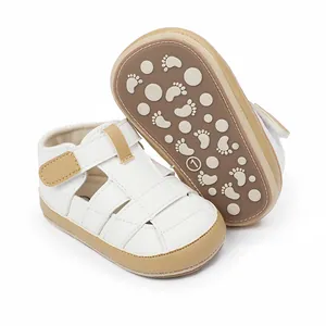 White and tan infant closed-toe sandals with non-slip footprint patterned soles