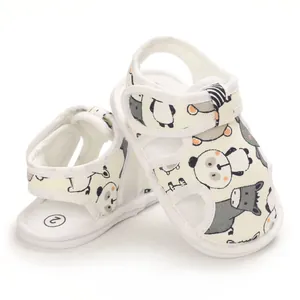 Detalle de sandalias para bebé con estampado de panda, velcro y suela blanda.