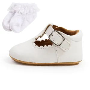 Dettaglio scarpa da principessa neonata bianca con bordi ondulati e calzini in pizzo