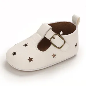 Side view detail of white baby sandals with hollow star cutouts and buckle strap