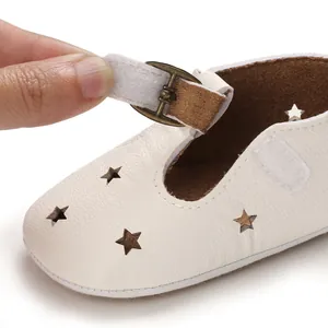 Close-up of the adjustable hook-and-loop strap on white star-cutout baby walker shoes