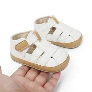 Breathable white baby sandals for infants, hand-held detail showing small scale.