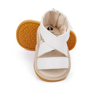 Détail de sandales d'été blanches pour bébé avec brides croisées et semelle en gomme
