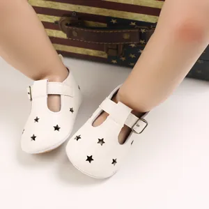 White PU leather baby shoes with star cutouts and soft soles for infants.