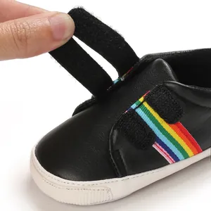 Gros plan détaillé de chaussure de marche bébé noire avec rayures arc-en-ciel et velcro