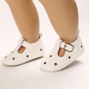 Detailed view of white baby pre-walker shoes with star cutouts and bronze buckle