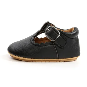 Detailed side view of black leather baby princess shoes with scalloped edges and buckle