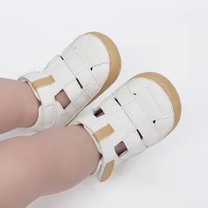 Detail of breathable white baby sandals with brown soles for newborn walking support.