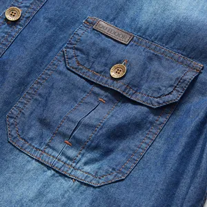 Detalle de bolsillo de camisa vaquera azul de hombre con parche de cuero y botones