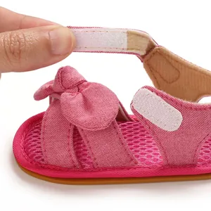 Detalle de sandalia rosa para bebé con correa de velcro ajustable y tejido de malla