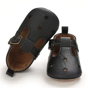 Close-up of black baby pre-walker shoes with star-shaped cutouts and soft leather texture