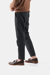Close-up detail of men's brown leather loafers with tassels and wood grain sole