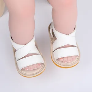 Détail de sandales d'été blanches à brides croisées pour bébé avec semelles en caoutchouc