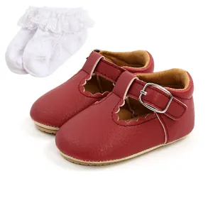 Dettaglio di scarpe da principessa rosse per neonata con calzini bianchi in pizzo e volant