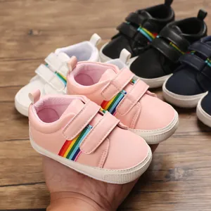 Vue détaillée des chaussures de marche roses pour bébés avec rayures arc-en-ciel