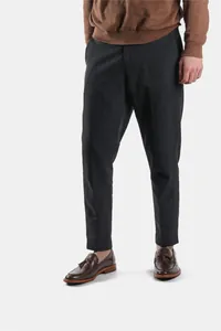Men's brown leather tassel loafers with wood grain soles paired with black trousers
