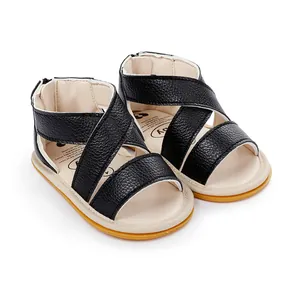Vue détaillée de sandales en cuir noir pour bébé avec brides croisées et semelle gomme