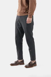 Full view of men's dark brown tassel loafers paired with grey trousers and sweater