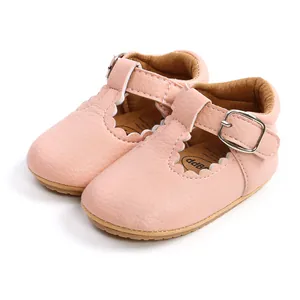 Macro view of pink leather baby princess shoes with scalloped edges and buckle