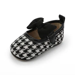 Detailansicht der Baby-Mädchen-Prinzessin-Schuhe mit Hahnentrittmuster und Samtschleife