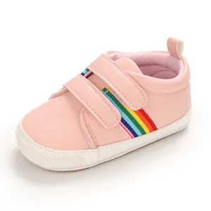 Chaussures de marche roses pour bébés avec rayures arc-en-ciel et semelles en caoutchouc.