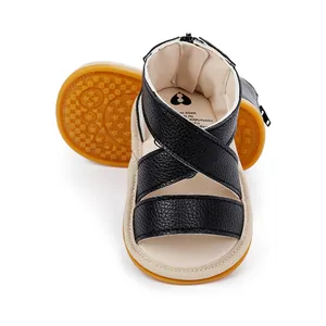 Détail de sandales pour bébé en similicuir noir avec semelles en caoutchouc et brides