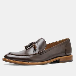 Side view of elegant brown leather loafers for men with tassel detail and wood grain sole.