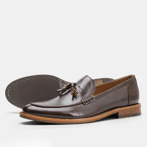 Detailed side view of dark brown leather loafers with tassel and wood grain heel