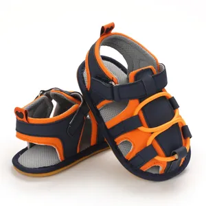 Dettaglio di sandali per neonati blu navy e arancioni con una comoda suola morbida
