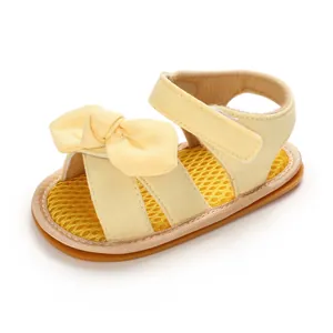 Detalle de perfil de sandalia de algodón amarillo para bebé con lazo y suela de goma
