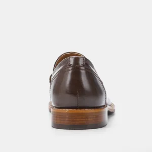 Detail shot of the wooden heel and leather back of a classic brown men's business loafer shoe.