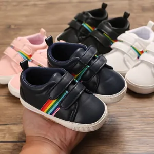 Chaussures de marche pour bébé avec rayures arc-en-ciel et semelles en caoutchouc souple.